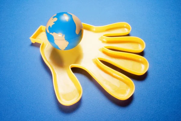 Globus auf Plastikhand — Stockfoto