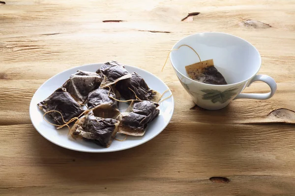 Tazza e piattino con bustine di tè — Foto Stock