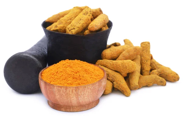 Whole and ground turmeric with mortar and pestle — Stockfoto