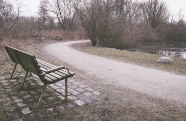 Bir parkta yalnız eski ahşap Bank