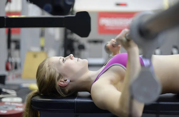 Mujer levantando pesas en el gimnasio —  Fotos de Stock