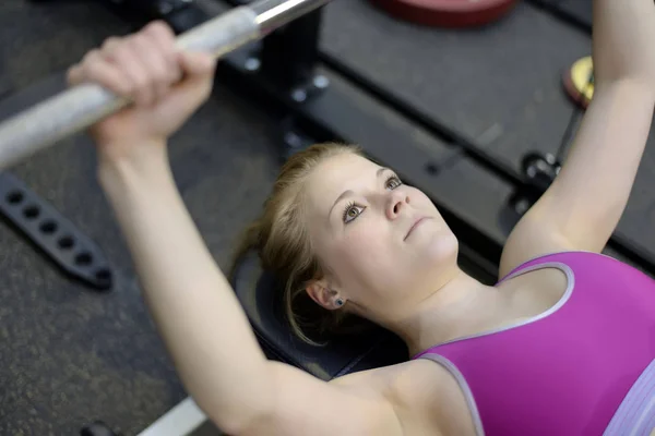 Mujer levantando pesas en el gimnasio —  Fotos de Stock