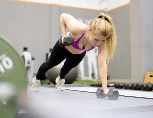 Mujer levantando pesas en el gimnasio —  Fotos de Stock