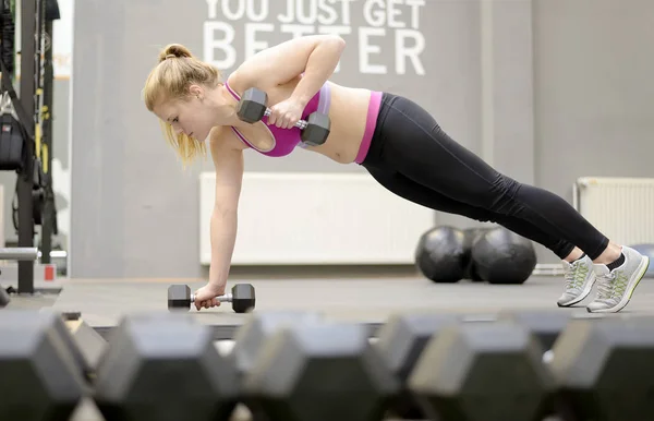 Mujer levantando pesas en el gimnasio —  Fotos de Stock