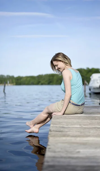 Frau sitzt auf See — Stockfoto