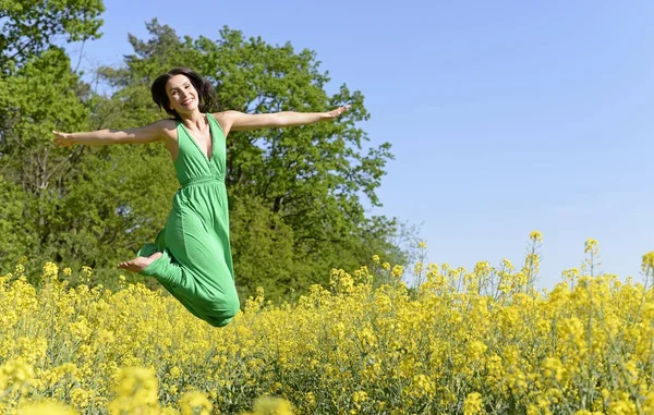 Jubelnde Junge Frau Springt Ins Rapsfeld Stockbild