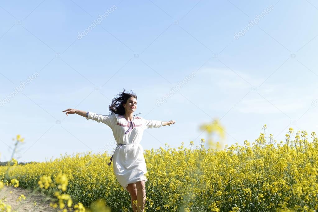  joyful young  woman leaping in the rape field