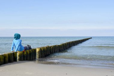  Sahilde, dikiz oturan düşünceli küçük kız