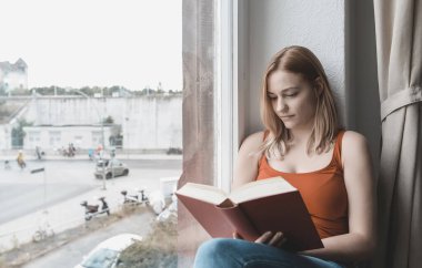 Kitap okuyan güzel genç bir kadın.