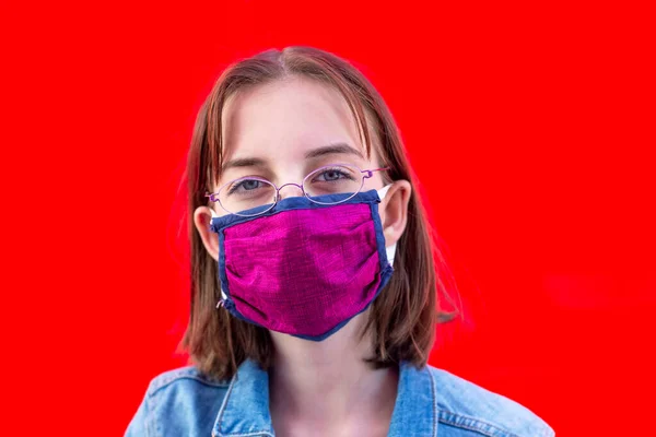 Mädchen Mit Mundschutz Und Brille Vor Rotem Hintergrund — Stockfoto