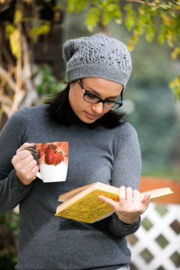Bir kitap okuma ve çay içme güzel genç kadın