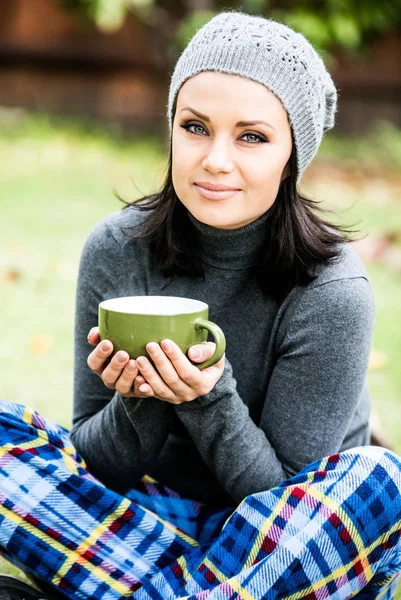 Güzel genç kadın gülümseyerek, çay içme