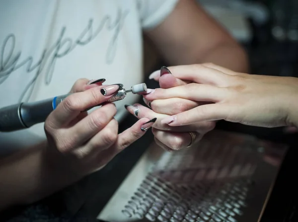 Mujer en un salón de uñas recibiendo una manicura por una esteticista — Foto de Stock