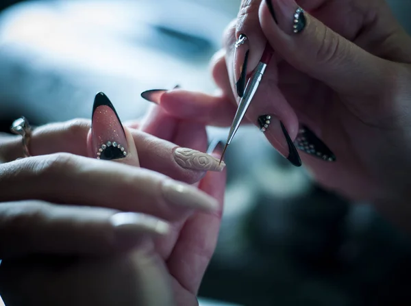 Woman in a nail salon receiving a manicure by a beautician — Stock Photo, Image