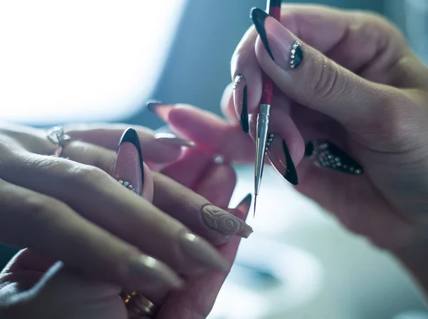 Žena v nehtový salon příjem manikúru od kadeřnice — Stock fotografie
