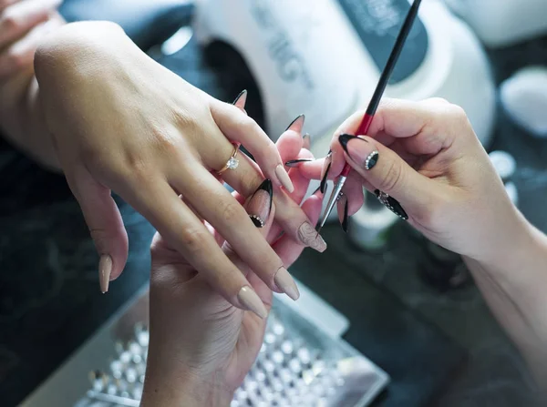 Mujer en un salón de uñas recibiendo una manicura por una esteticista —  Fotos de Stock
