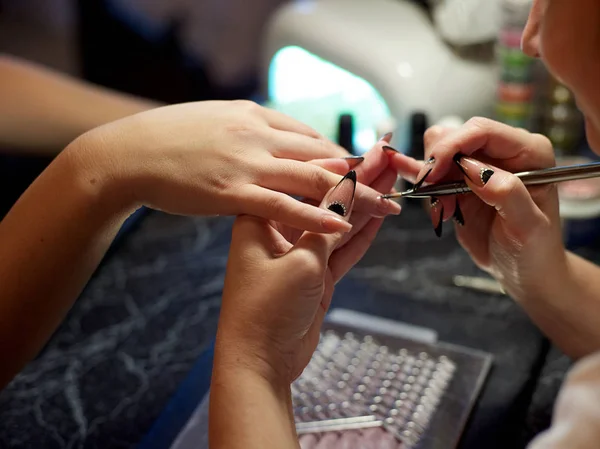 Woman in a nail salon receiving a manicure by a beautician with nail file woman — Stock Photo, Image