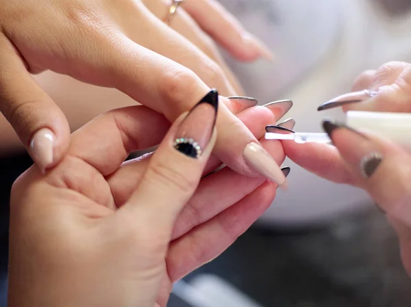 Woman in a nail salon receiving a manicure by a beautician with nail file woman — Stock Photo, Image
