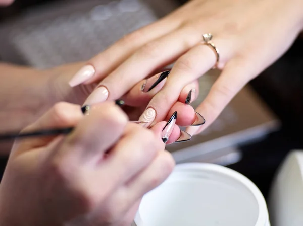 Mujer en un salón de belleza recibiendo una manicura por una esteticista con lima de uñas mujer — Foto de Stock