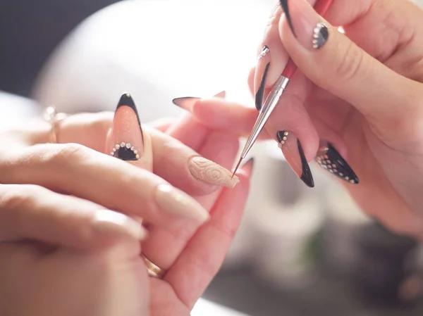 Mujer en un salón de belleza recibiendo una manicura por una esteticista con lima de uñas mujer — Foto de Stock