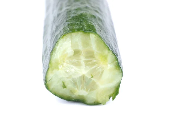 Pepino verde mordido sobre un fondo blanco — Foto de Stock