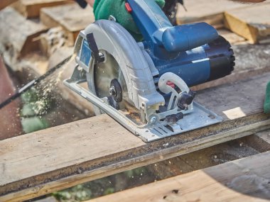 Builder bir daire testere ile tahta keser