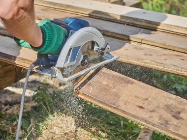 Builder bir daire testere ile tahta keser