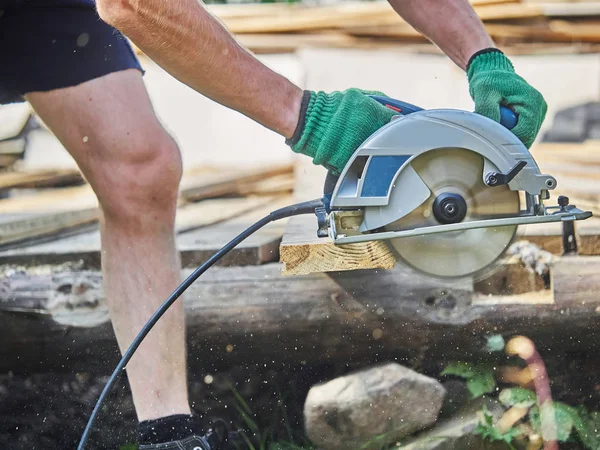 Builder bir daire testere ile tahta keser — Stok fotoğraf