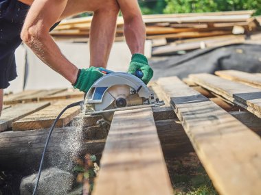 Builder bir daire testere ile tahta keser