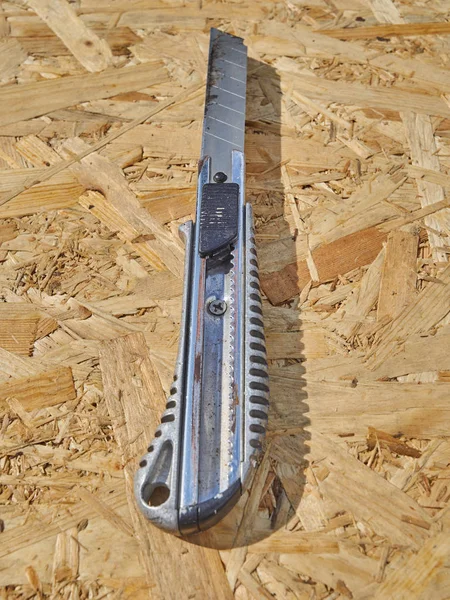 Construction knife on a wooden background — Stock Photo, Image