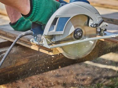 Builder bir daire testere ile tahta keser