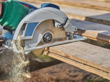 Builder bir daire testere ile tahta keser