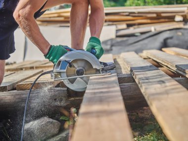 Builder bir daire testere ile tahta keser