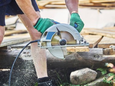 Builder bir daire testere ile tahta keser