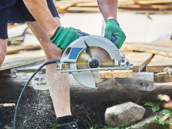 Builder bir daire testere ile tahta keser — Stok fotoğraf