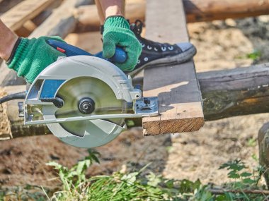 Builder bir daire testere ile tahta keser