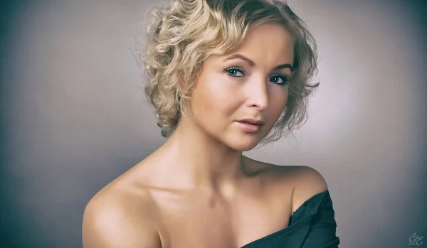 Hermosa chica en un vestido negro sobre un fondo gris —  Fotos de Stock