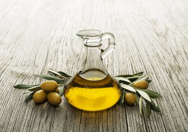 Olive oil bottle on wooden background clipart