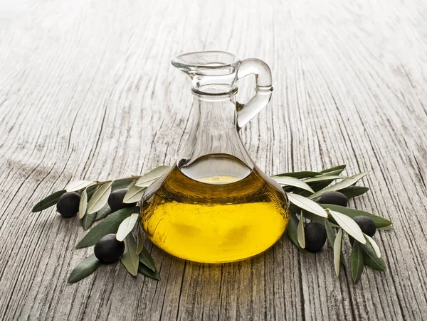 Olive oil bottle on wooden background — Stock Photo, Image