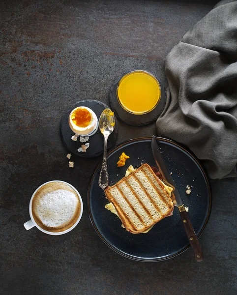 Mesa de desayuno continental con tostadas, huevo, zumo y café — Foto de Stock