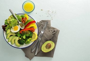 Sağlıklı salata menüsü, kinoa, yumurta, avokado ve mavi arka planda taze sebzeler. Yiyecek ve sağlık. Sağlıklı yemek kavramı