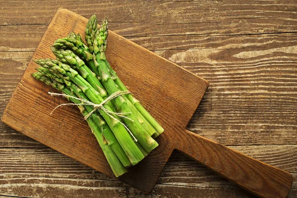 Asparagus. Fresh Asparagus. Pickled Green Asparagus. Bunches of green asparagus on wooden table, top view- Image