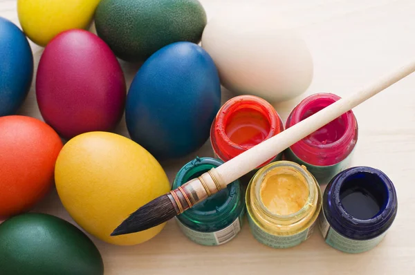 用刷子给复活节彩蛋上色 并在木制桌子上涂上油漆 — 图库照片
