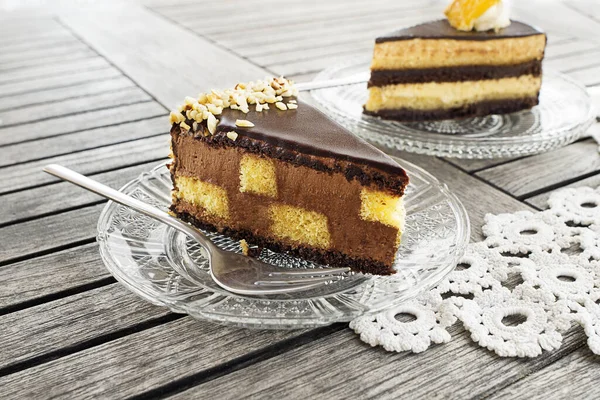 切碎美味的巧克力蛋糕与奶油和坚果在木制桌子的背景 巧克力蛋糕片 — 图库照片