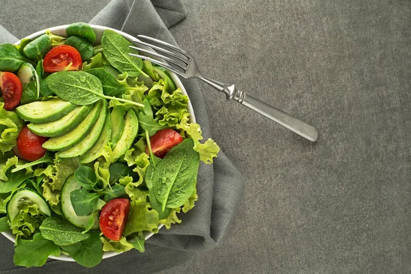 灰色のテーブルの上にアボカドと健康的なグリーンサラダ — ストック写真