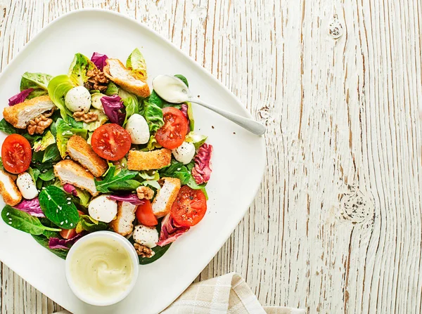 Kızarmış tavuk, peynir ve domatesli sağlıklı salata.