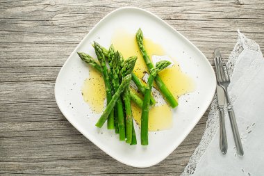 Kuşkonmaz. Yeşil kuşkonmaz. Tabakta sos soslu haşlanmış kuşkonmaz. Kapatın.