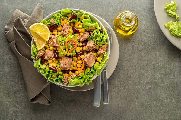 Healthy Green salad with tuna, corn and beans on grey background. Mexican corn salad.