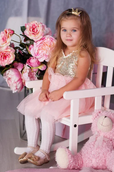 Pretty child girl is sitting on pink chair — Stock Photo, Image