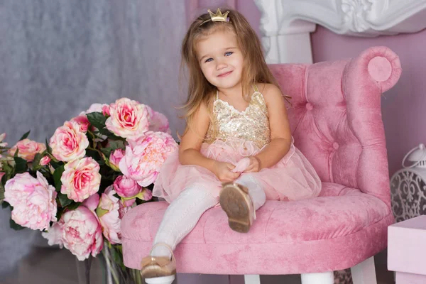 Pretty child girl is sitting on pink chair — Stock Photo, Image